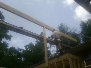 Carpenter setting a ridge beam over a new addition frame — Ice Dam Removal by Roofing Brothers in Pineland