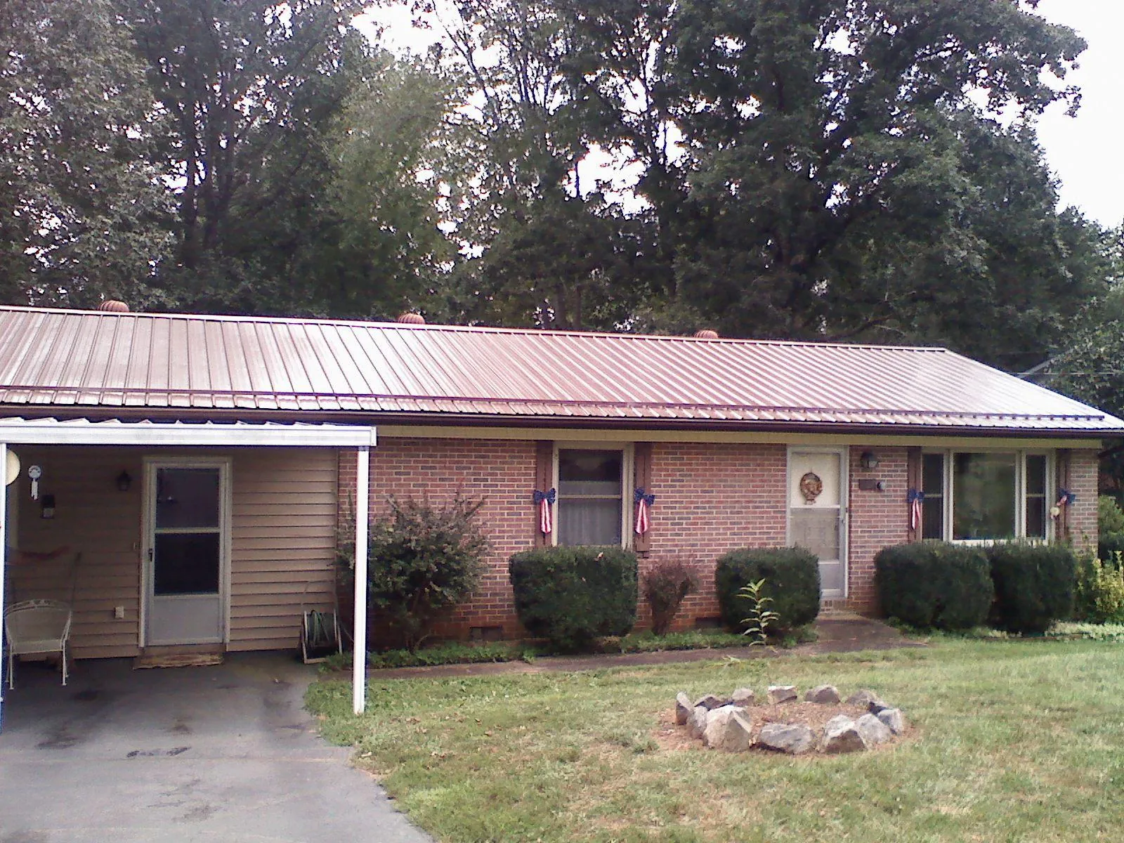 Bronze metal roof and carport on a brick ranch home — Roof Repair work by our crew in Pineland